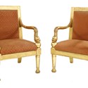 A pair of gilt armchairs with dolphin arms.jpg