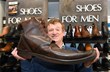 David Gummers with a giant brown boot - one of two - being auctioned by 1818 Auctioneers on Tues 6 August..jpg