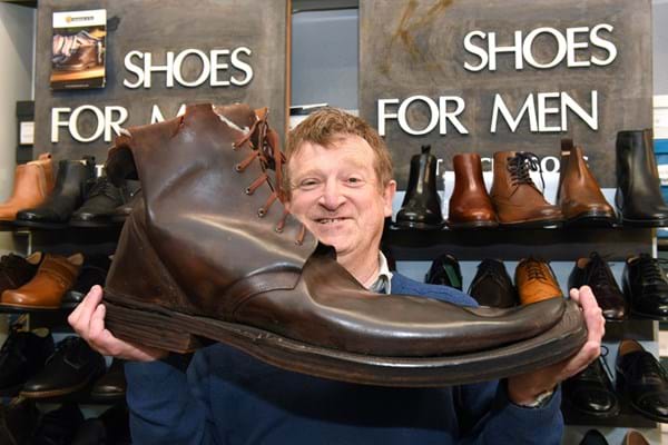 David Gummers with a giant brown boot - one of two - being auctioned by 1818 Auctioneers on Tues 6 August..jpg