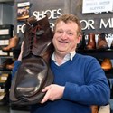 David Gummers with a giant brown boot, one of two, being auctioned by 1818 Auctioneers on Tues 6 August..jpg