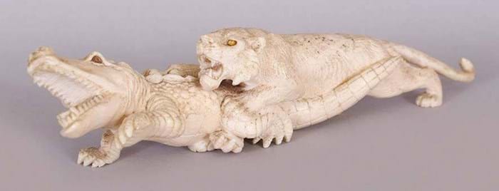 An ivory lion attacking a crocodile