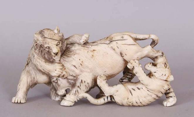 An ornament of a bear and a tiger attacking a boar