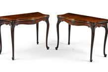 A pair of George III carved mahogany serpentine fold-over tables.